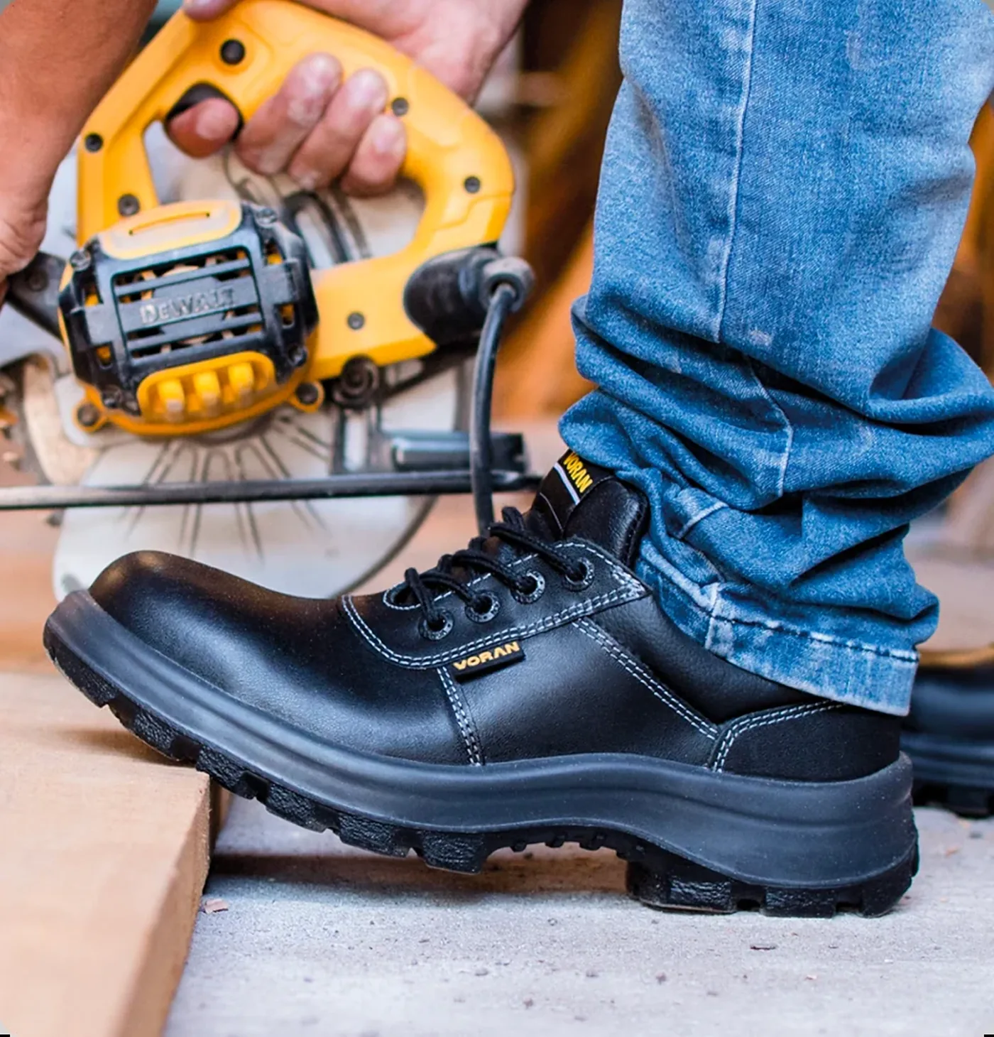 Trabajador con zapatos de seguridad Voran Industrial Flex usando una sierra
